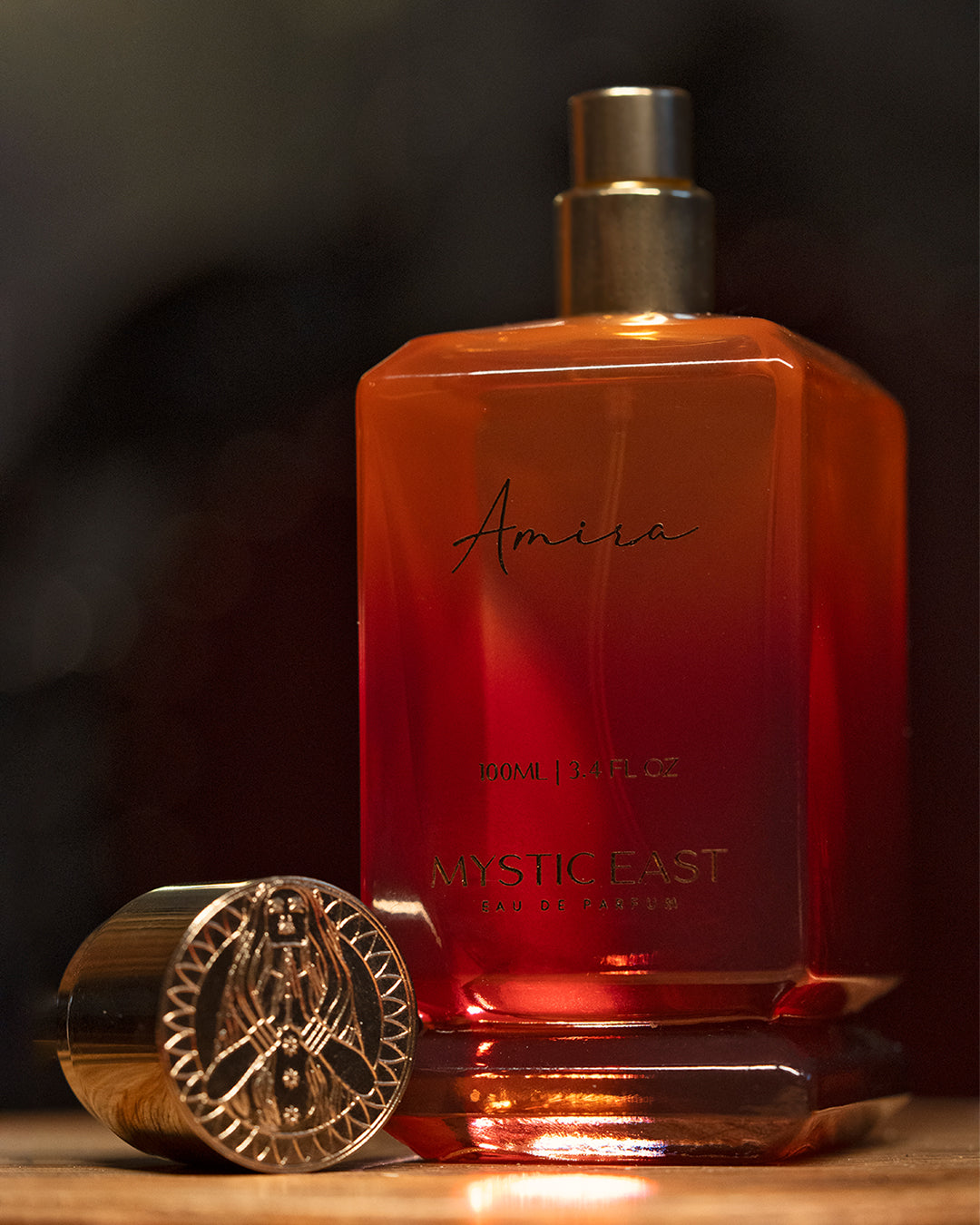 Red perfume bottle with gold cap on a dark background