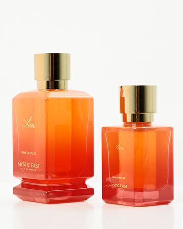 Two orange perfume bottles with gold caps on a white background