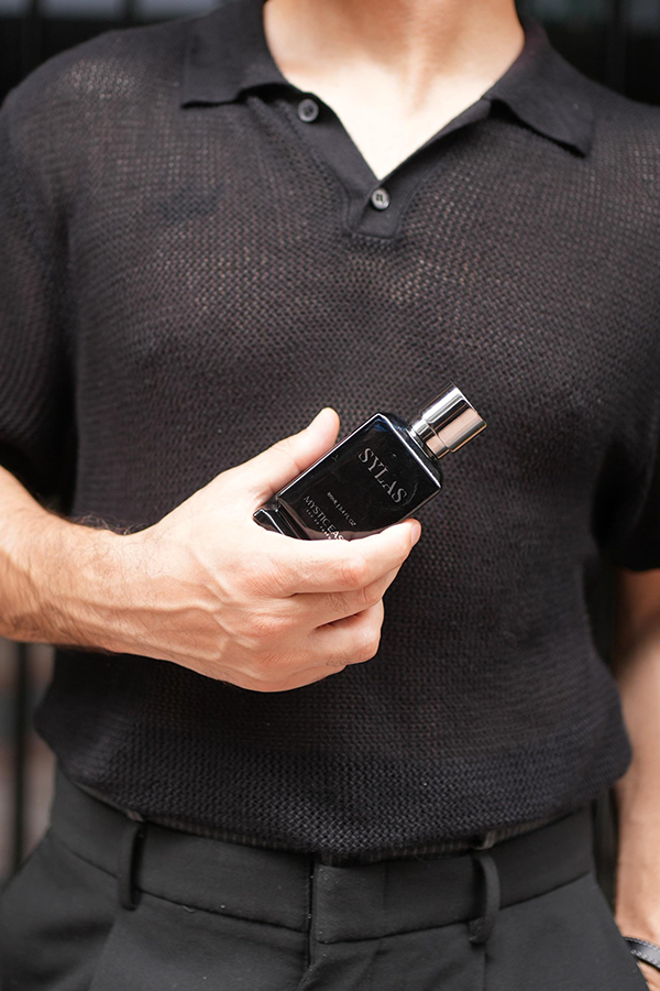 Person holding a black vape device with 'Nyles' branding.